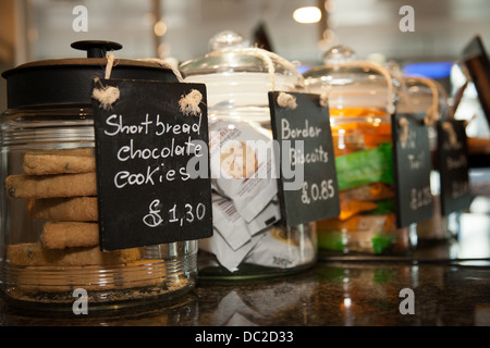 Les cookies au chocolat sablés et autres biscuits dans de grands pots sur un comptoir dans un café de Londres. Banque D'Images