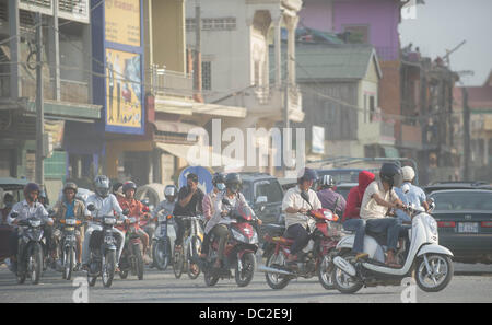 Phnom Penh, Cambodge. 3 janvier, 2013. Jan 3, 2013 - Moto pilotes utilisent des masques pour protéger contre le smog, qui font peu pour filtrer les particules et gaz nocifs de la pollution atmosphérique, comme ils naviguer à travers la capitale cambodgienne de Phnom Penh.story Résumé : Il est dit que la bataille sur le réchauffement climatique est d'être gagné ou perdu en Asie. Banque D'Images