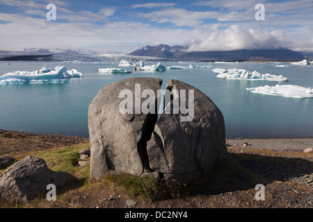 Split Rock et des icebergs dans la Lagune glaciaire du Jökulsárlón Le Parc national du Vatnajökull en Islande Banque D'Images