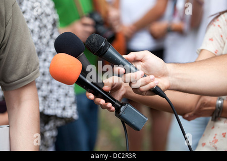 Un journaliste fait une interview avec un microphone Banque D'Images