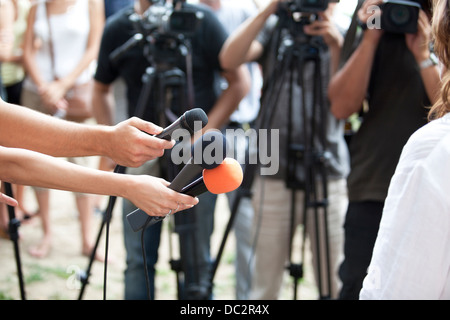 Un journaliste fait une interview avec un microphone Banque D'Images