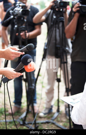 Un journaliste fait une interview avec un microphone Banque D'Images