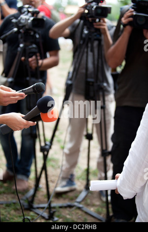 Un journaliste fait une interview avec un microphone Banque D'Images