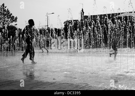 Les enfants jouent dans les fontaines de la place dans le grenier, King's Cross, Londres, UK Banque D'Images