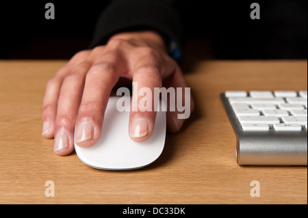 Close-up of young lady's main sur ordinateur avec la souris du clavier dans l'image. Banque D'Images