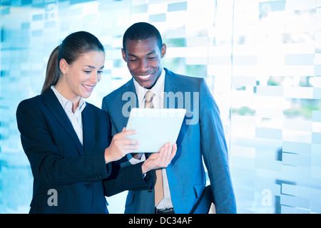 Smiling businessman and businesswoman using digital tablet Banque D'Images