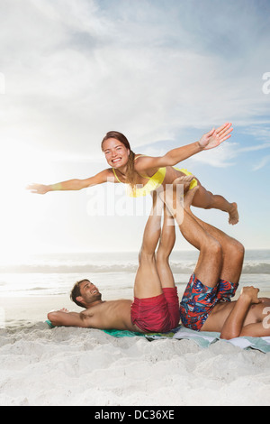 Hommes Femme de levage avec les jambes sur la plage Banque D'Images