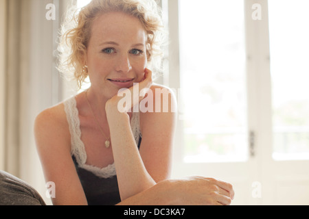 Portrait of smiling woman with head in hands Banque D'Images