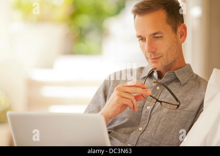 Pensive man using laptop Banque D'Images