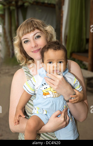 Belle et heureuse mère de l'Afrique de l'adorable baby boy hugging noir. La notion d'enfance et de la famille. Banque D'Images