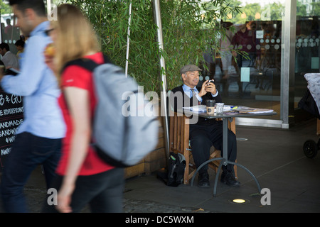 Gentleman travaillant dans un tableau à la BFI Southbank sur le café. La Banque du Sud est un important quartier des spectacles, c'est promenade Riverside occupé avec les visiteurs et les touristes. Londres, Royaume-Uni. Banque D'Images