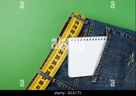 Jeans avec ceinture mètre portable et minceur dans Pocket sur le fond vert Banque D'Images