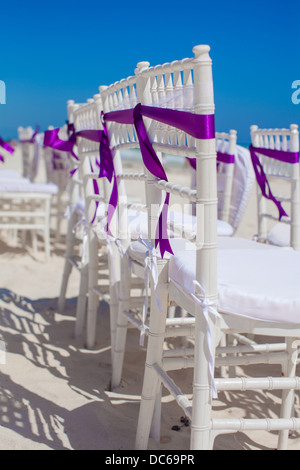 Chaises de mariage blanc violet décoré avec des arcs on sandy beach Banque D'Images