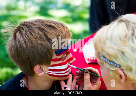 Jeune garçon ayant drapeau américain peint sur son visage lors d'une célébration du 4 juillet. Banque D'Images