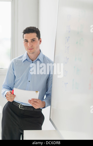 Businessman standing next to whiteboard Banque D'Images