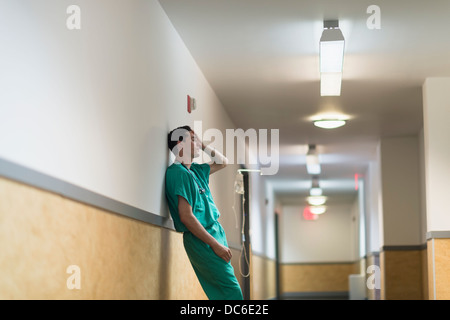 Tired doctor standing in hallway Banque D'Images