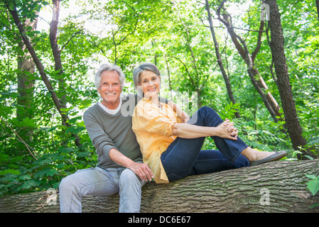 USA, New York State, New York, Central Park, Senior couple sitting on log in forest Banque D'Images