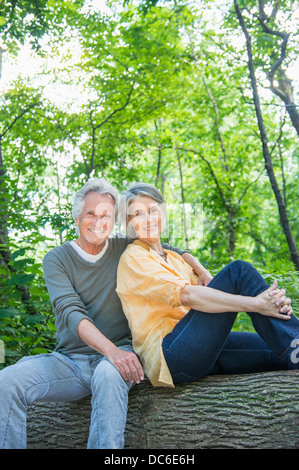 USA, New York State, New York, Central Park, Senior couple sitting on log in forest Banque D'Images