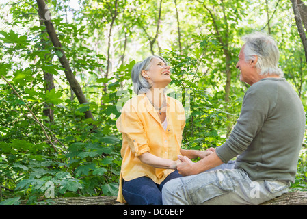 USA, New York State, New York, Central Park, Senior couple sitting on log in forest Banque D'Images