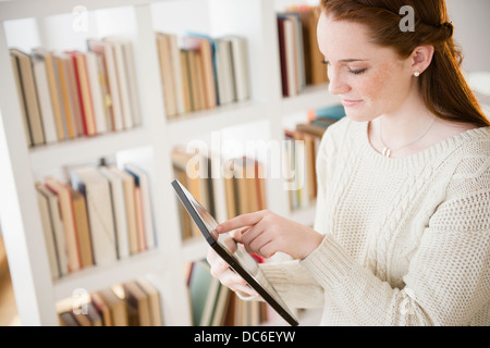 Teenage girl (14-15) using digital tablet Banque D'Images