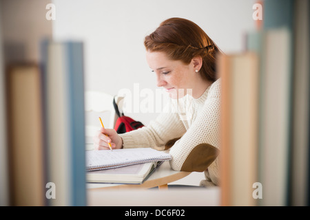 Teenage girl (14-15) studying in library Banque D'Images