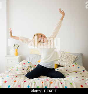 Young woman stretching in bed Banque D'Images