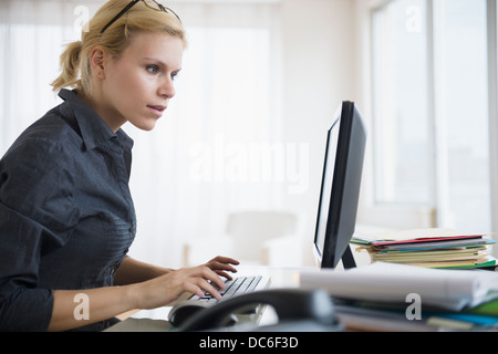 Young woman working at desk in office Banque D'Images