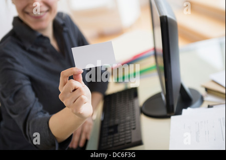 Young woman showing blank business card Banque D'Images