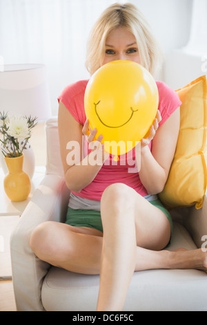 Young woman blowing balloon Banque D'Images