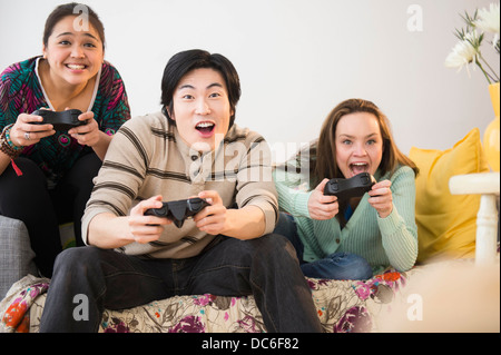 Les jeunes femmes et man playing video game Banque D'Images