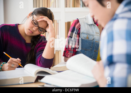 Les jeunes femmes et l'homme studding in library Banque D'Images