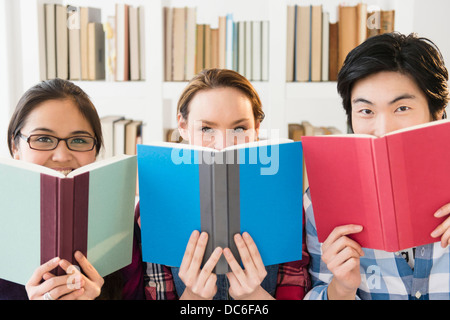 Les jeunes femmes et l'homme studding in library Banque D'Images