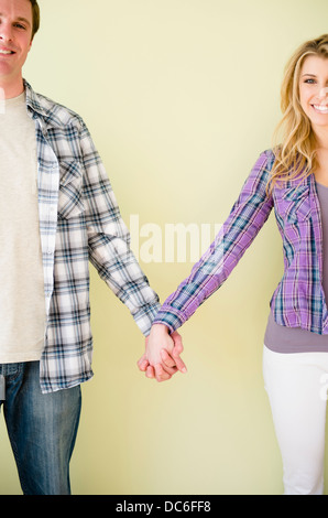 Studio shot of couple holding hands Banque D'Images