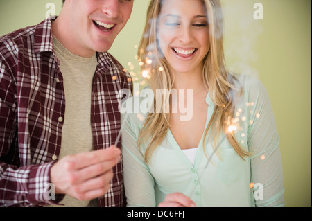 Studio shot of couple holding sparklers Banque D'Images