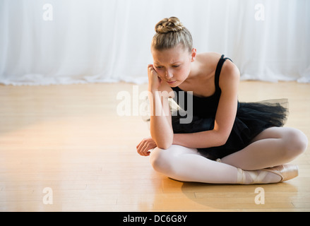 Portrait de fatigué teenage (16-17) ballet dancer sitting on floor Banque D'Images