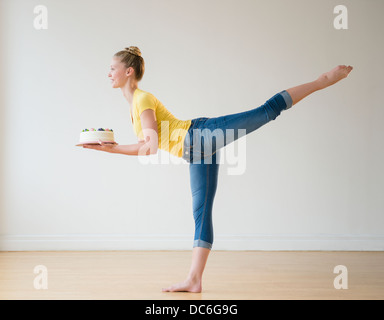 Portrait of teenage (16-17) ballerina holding cake Banque D'Images