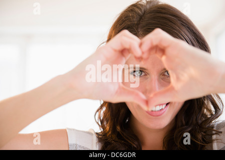 Portrait de jeune femme en forme de coeur avec ses mains Banque D'Images