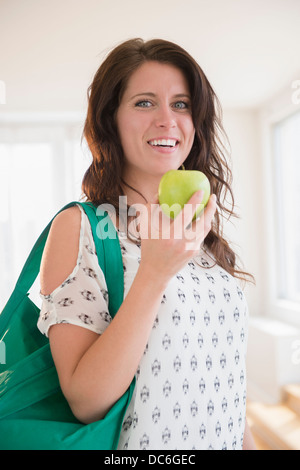 Portrait of young woman holding green apple Banque D'Images