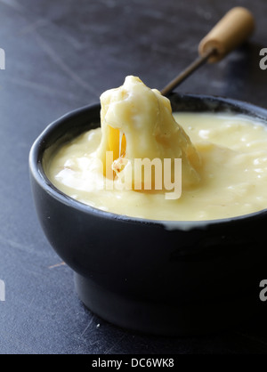 Fondue au fromage - morceau de pain (1900) dans un liquide fromage Banque D'Images