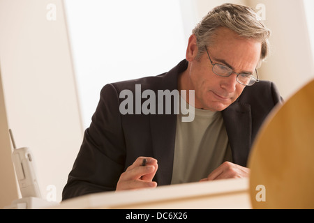 L'homme d'affaires d'âge mûr se concentrant sur travailler Banque D'Images