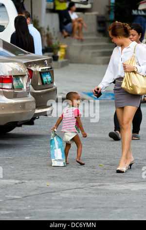 Petits garçons mendicité dans la ville de Makati à Manille, Philippines Banque D'Images