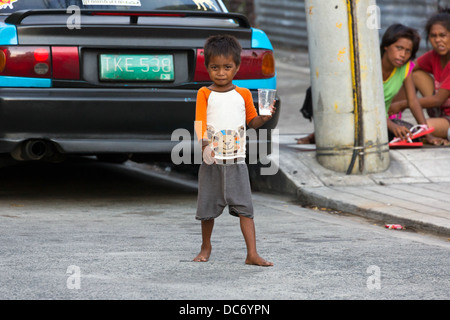 Petits garçons mendicité dans la ville de Makati à Manille, Philippines Banque D'Images