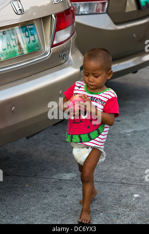 Petits garçons mendicité dans la ville de Makati à Manille, Philippines Banque D'Images