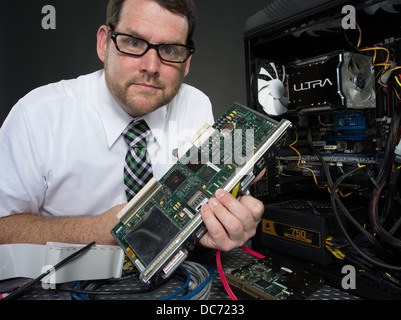 Homme avec ordinateur et divers composants matériels Banque D'Images