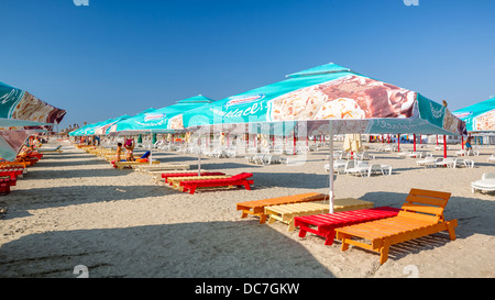 Rangée de fonds marins colorés et des parasols sur une plage de sable Banque D'Images