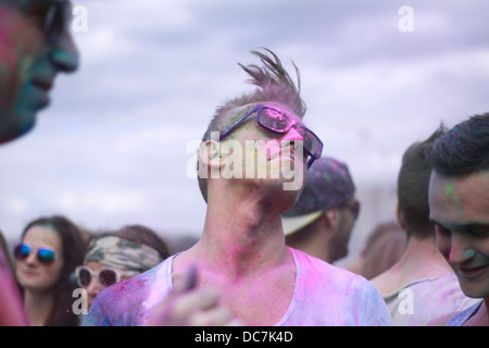 Girl couverts en bleu couleur holi poudre couleur fun exciter rire festival concert face couverte d'hommes masculins nuances swag swing Banque D'Images