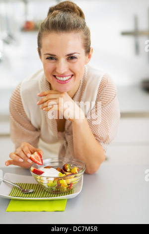 Jeune femme au foyer salade de fruits de décoration Banque D'Images