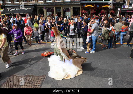 Edinburgh, Royaume-Uni. Août 11, 2013. La foule regarder un artiste de rue habillés comme des clowns sur le Royal Mile à Édimbourg Crédit : PictureScotland/Alamy Live News Banque D'Images