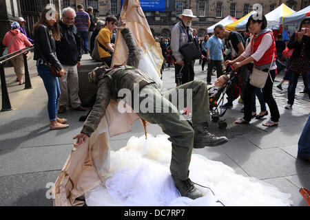 Edinburgh, Royaume-Uni. Août 11, 2013. Passants sur le Royal Mile d'Édimbourg se divertir en regardant un artiste de rue habillés comme Amelia Earhart. Credit : PictureScotland/Alamy Live News Banque D'Images
