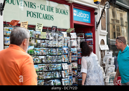 Les personnes à la recherche de cartes postales au magasin de souvenirs à Cambridge, Angleterre Banque D'Images